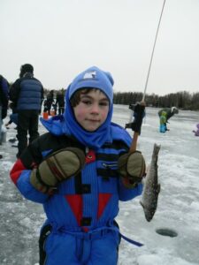 Tracy's son Lucas holding a fish after ice fishing.