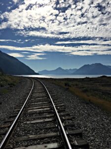 Hiking and biking into wilderness inspire taking heart in the wild. Here, train tracks reach toward a blue sky along Turnagain Arm.