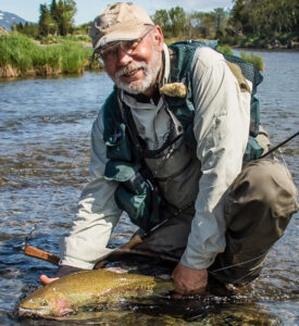 Bill holding a fish in water before letting it go.